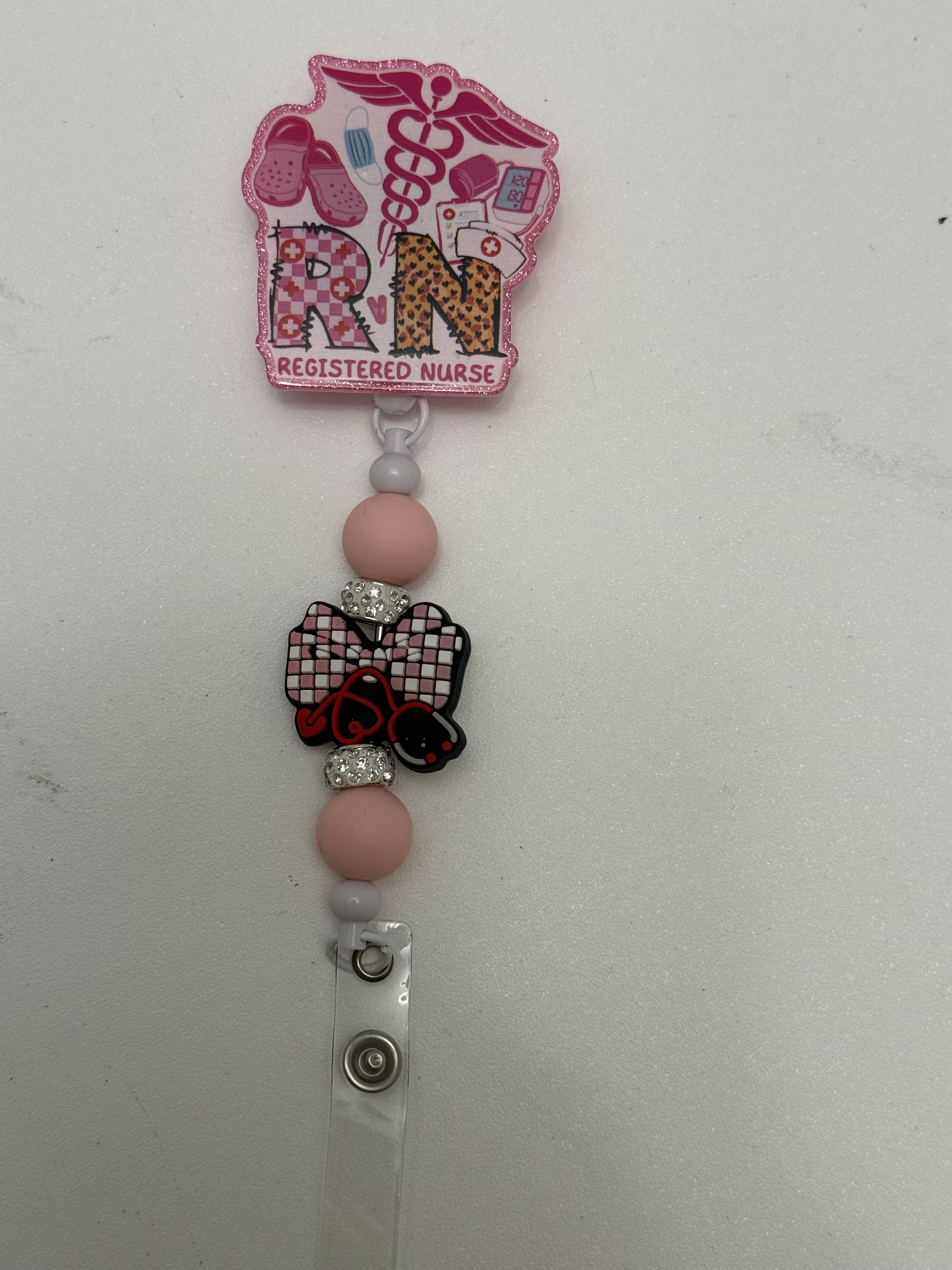 Pink glitter RN badge reel with beads, rhinestone spacers, and kawaii bow focal bead