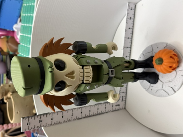 3D printed skeleton nutcracker in olive uniform with auburn hair and pumpkin base