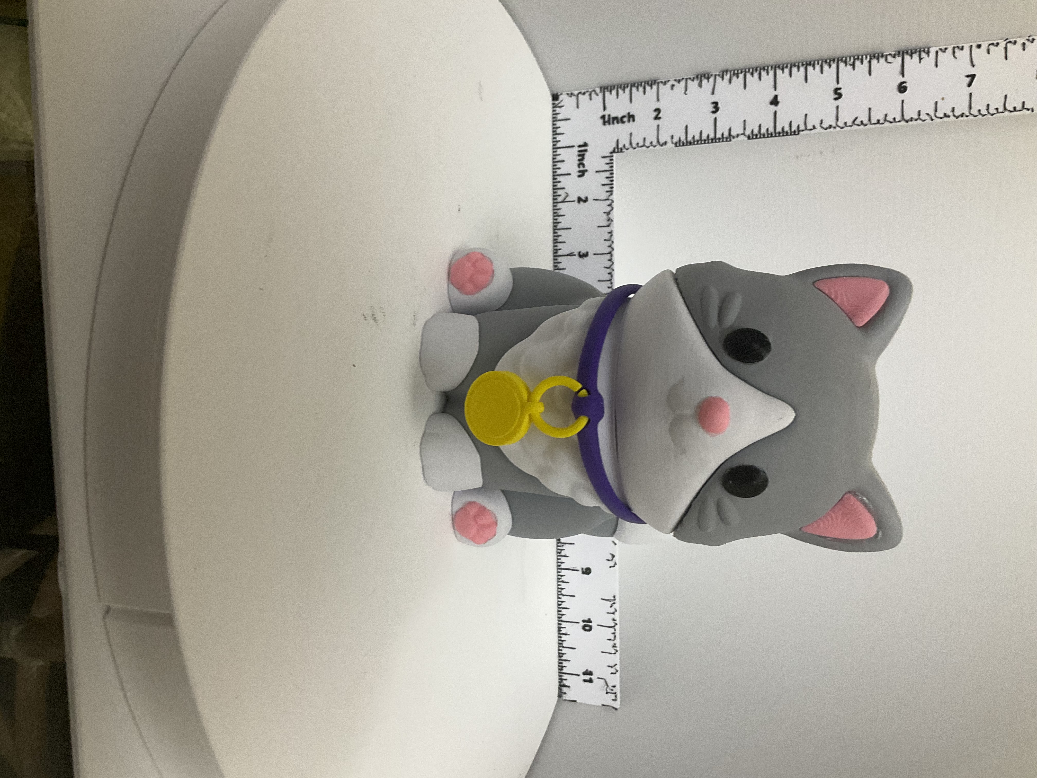Front view of grey and white kawaii cat soap dispenser holder with purple collar and yellow medallion