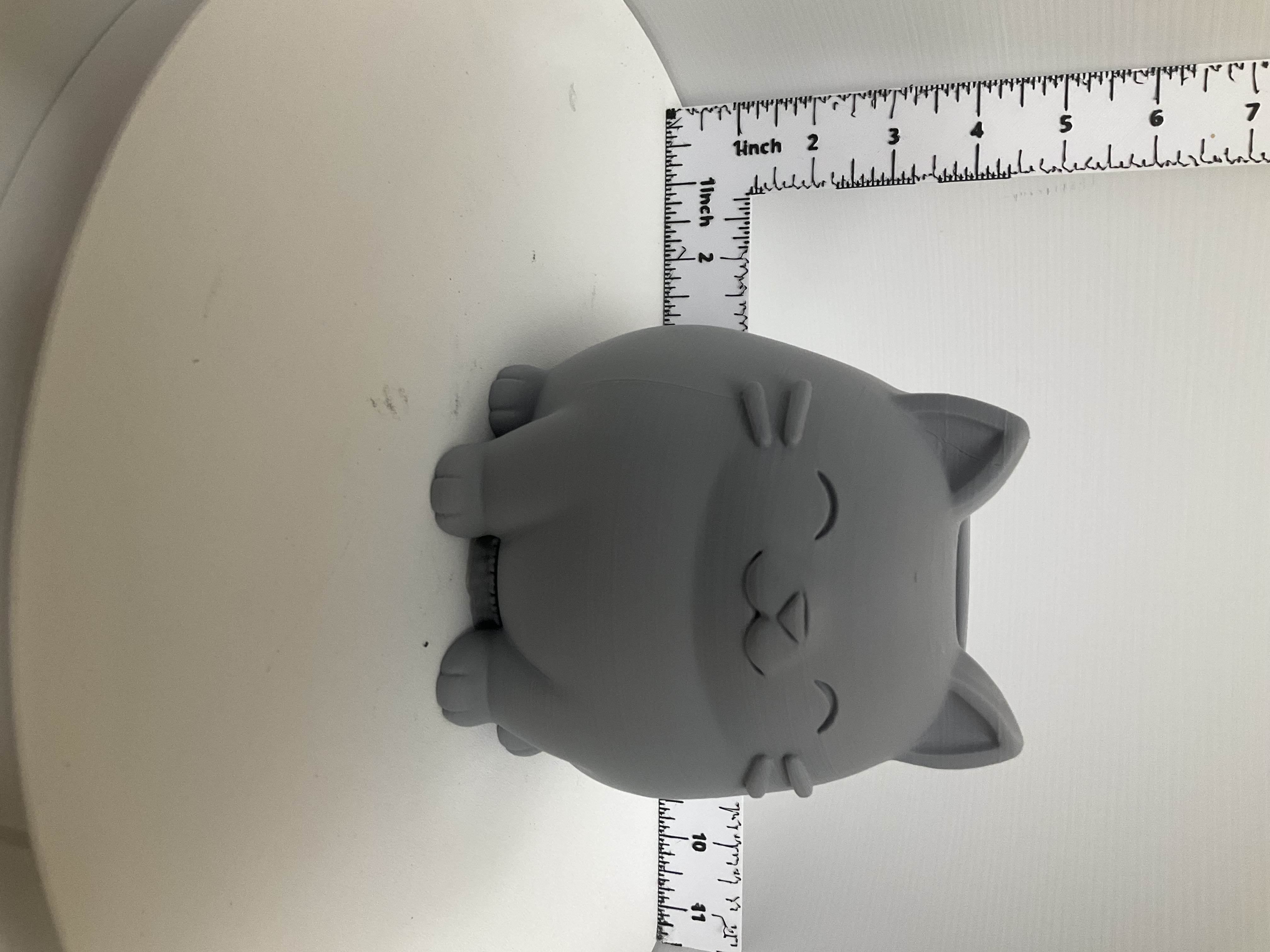 Front view of round grey cat planter with smiling face whiskers and tiny paws