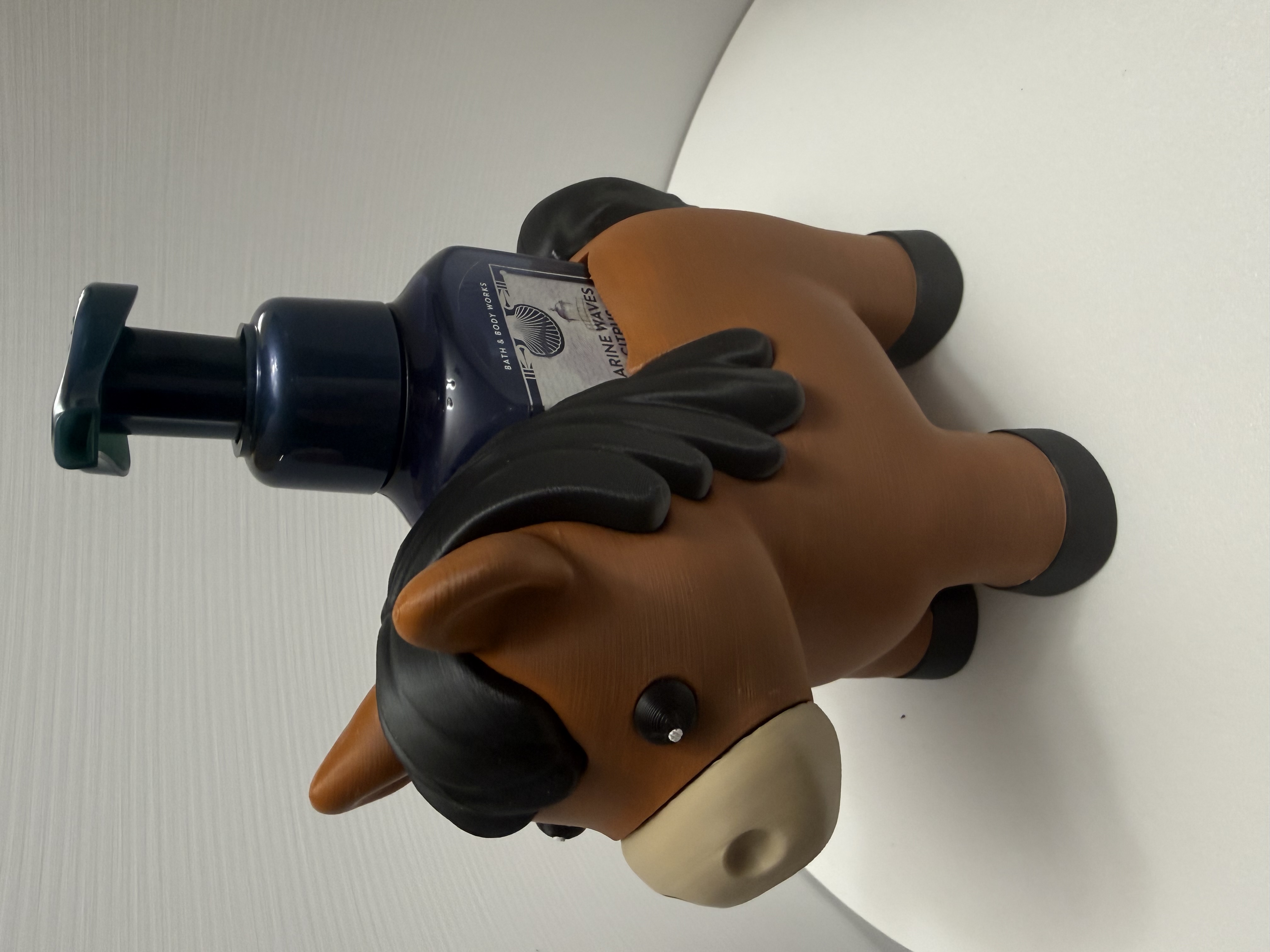 Front view of chestnut pony soap holder cradling a navy foam pump bottle