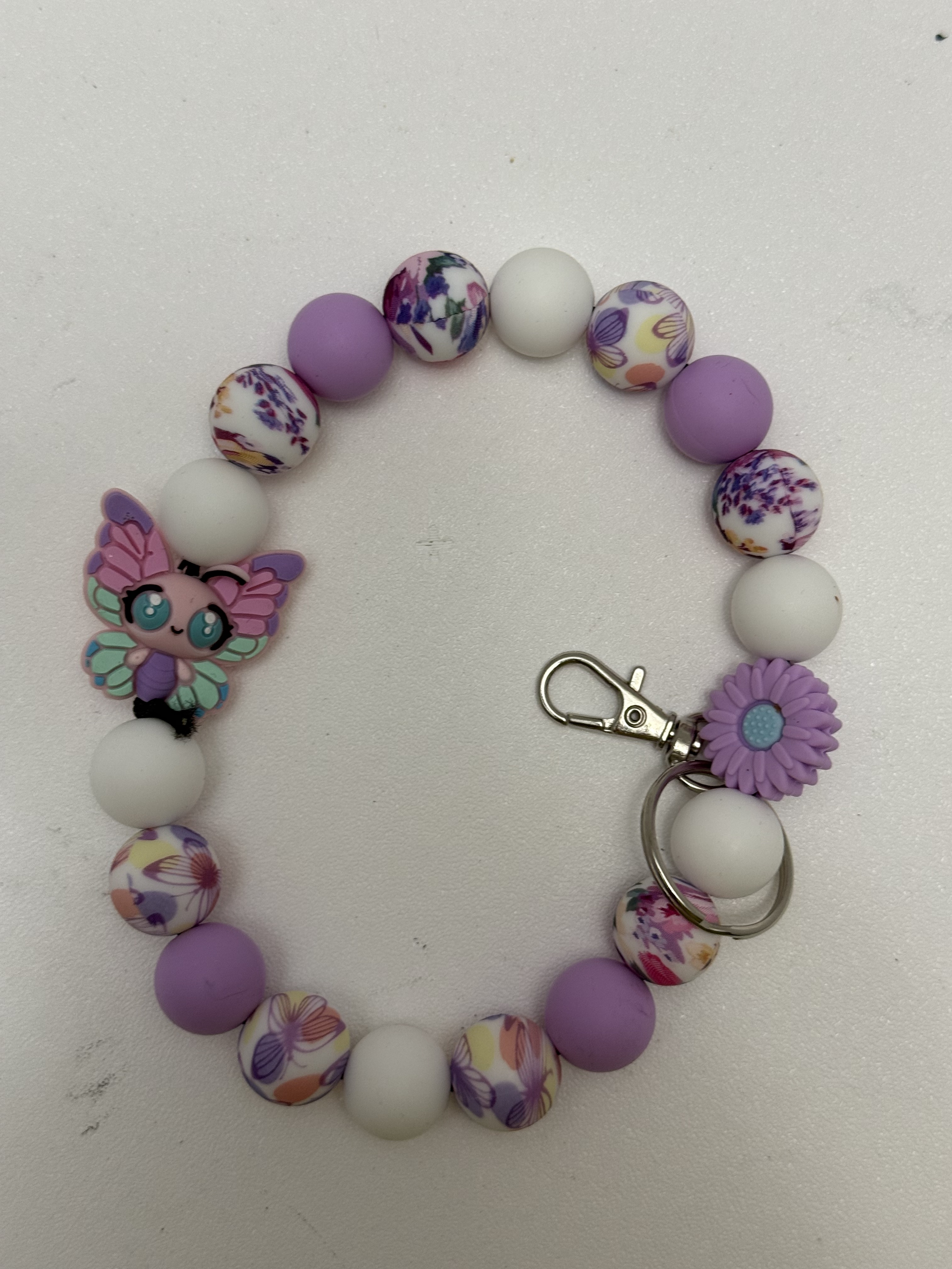 Beaded wristlet key chain with lavender, white, and floral beads and kawaii butterfly focal charm