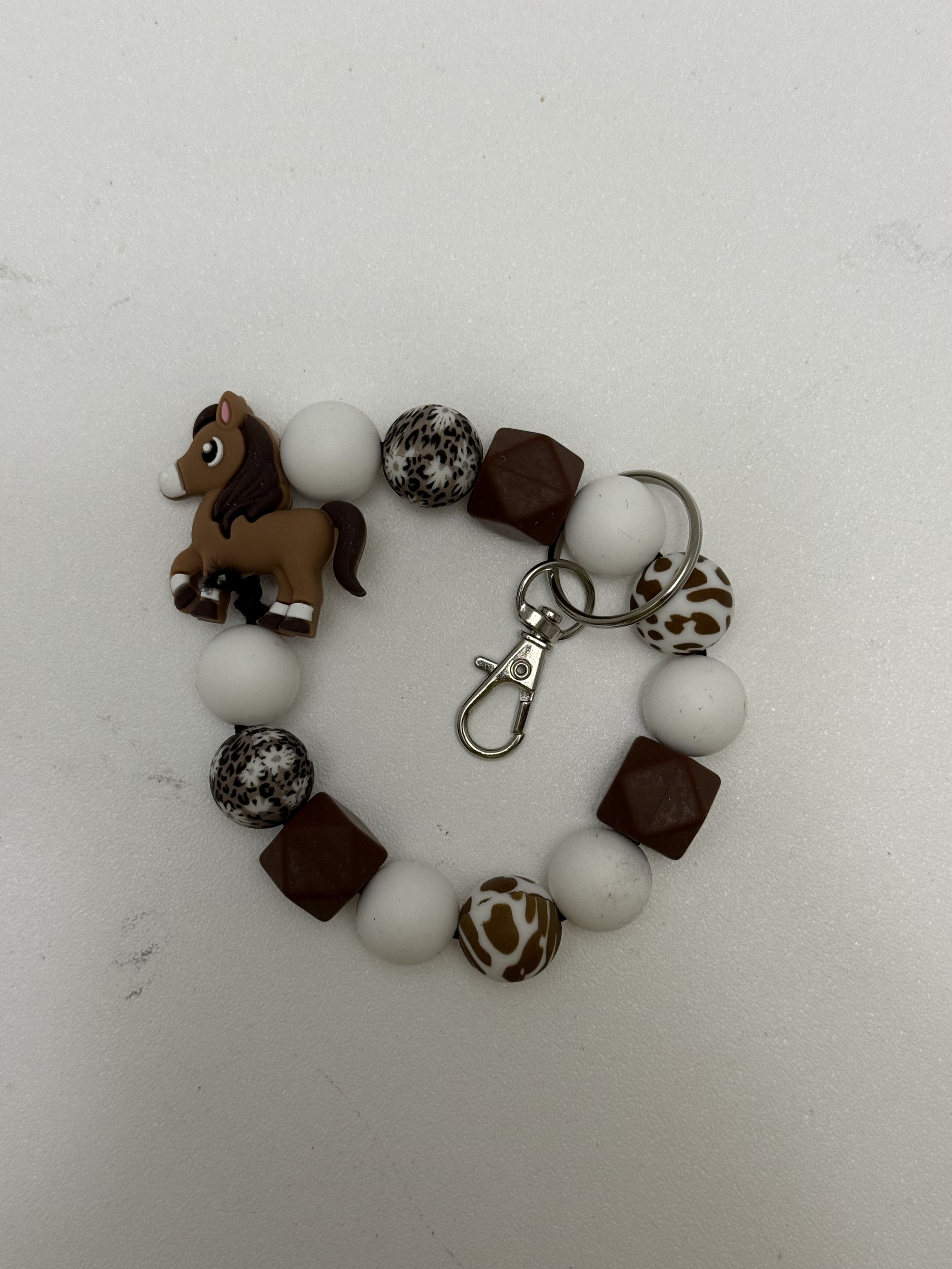 Stretchy beaded wristlet keychain with kawaii pony focal bead, white and brown beads, silver lobster clasp