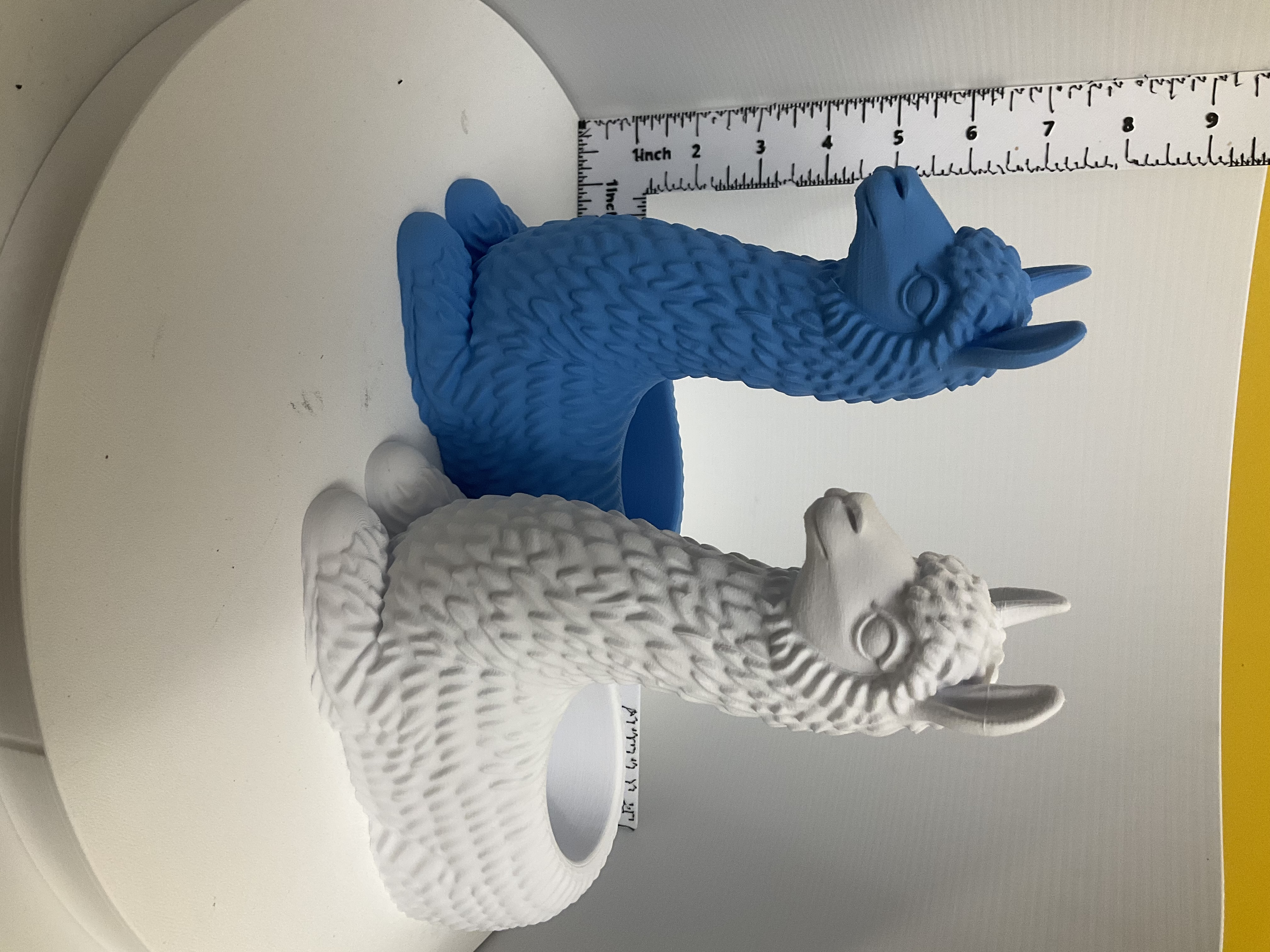 Blue and white llama planters side by side shown with ruler for scale