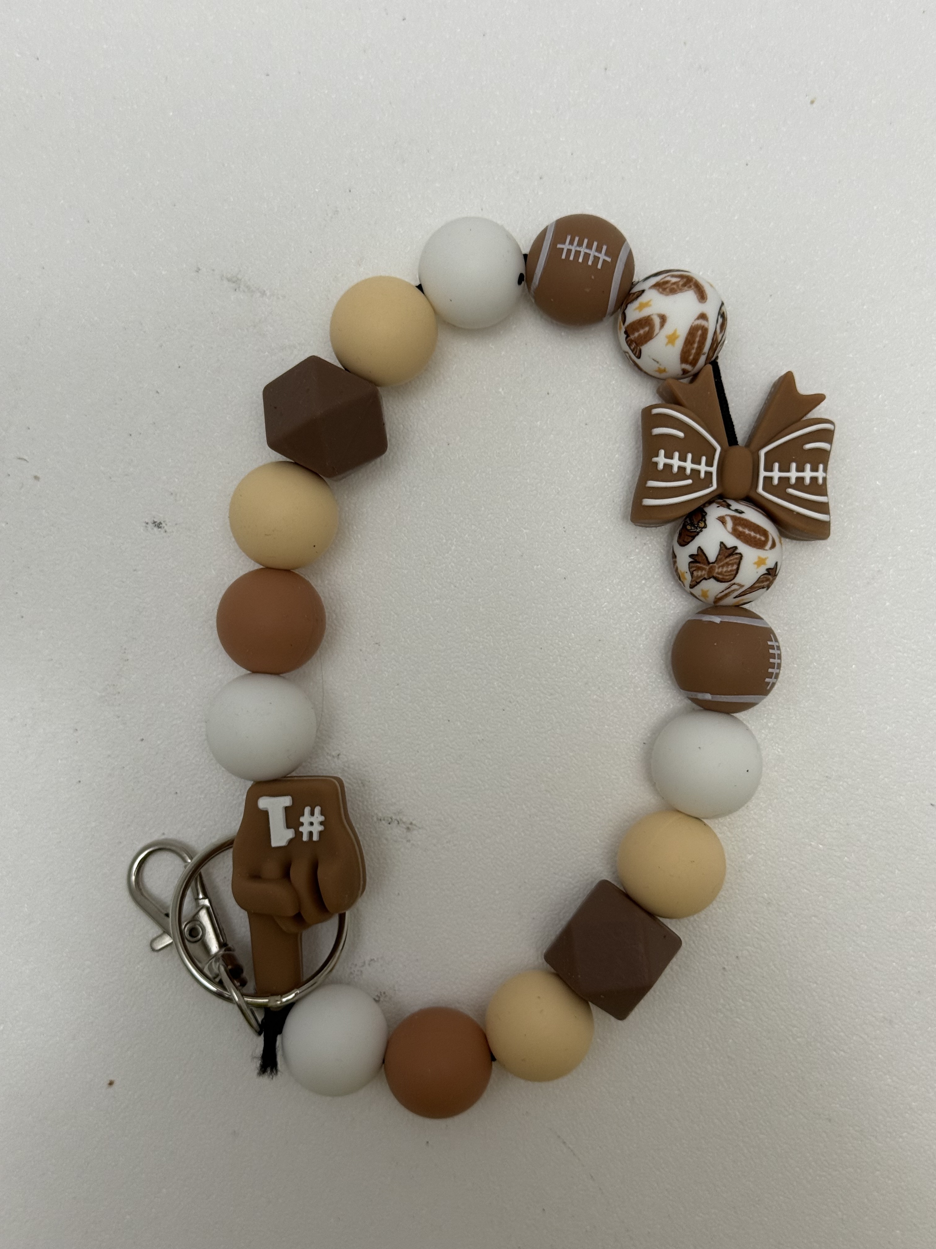 Beaded football wristlet keychain with caramel cream and tan beads, bow focal, and silver clasp