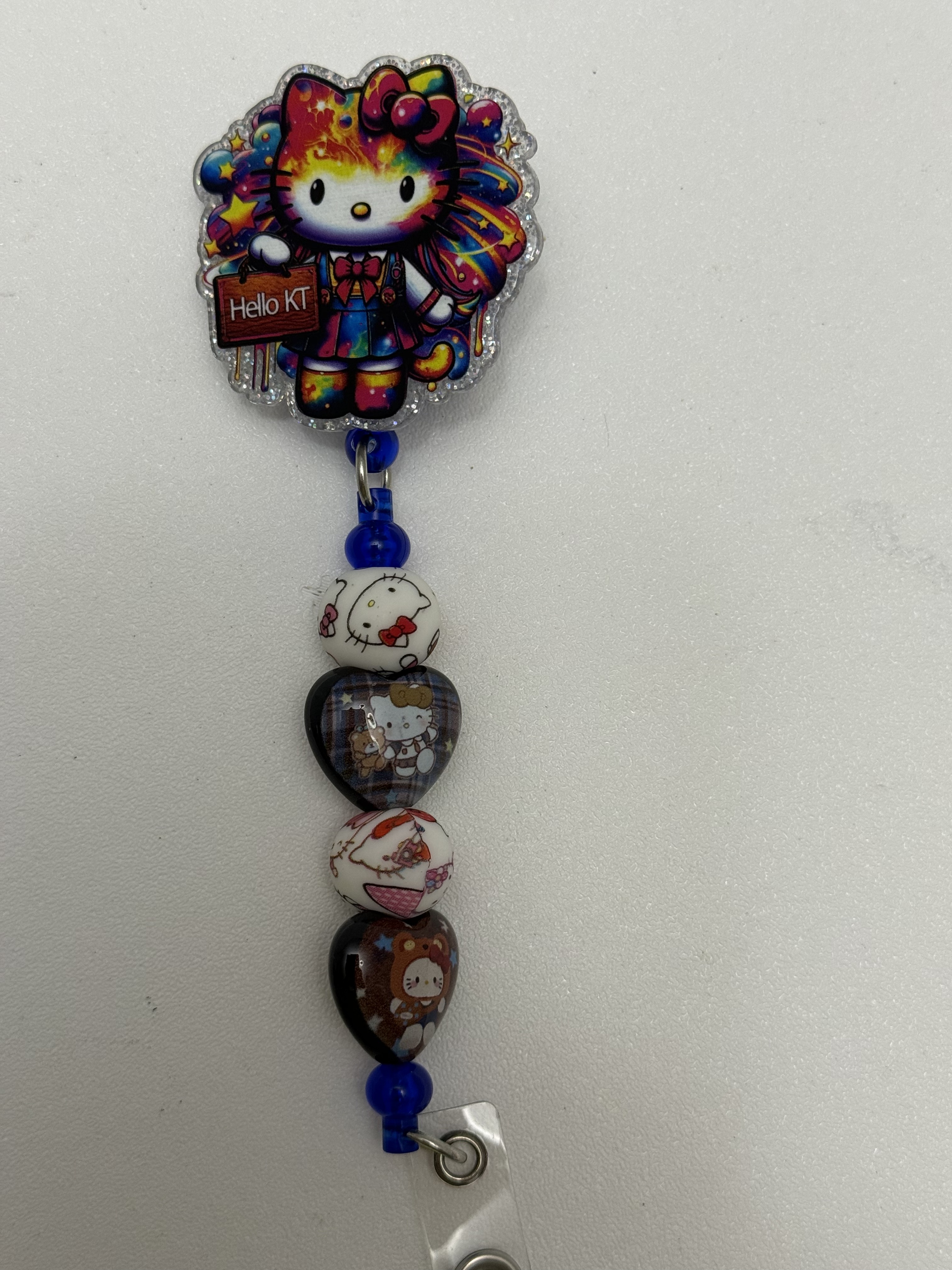 Retractable badge reel with galaxy kawaii cat acrylic topper and printed character beads on cobalt blue strand