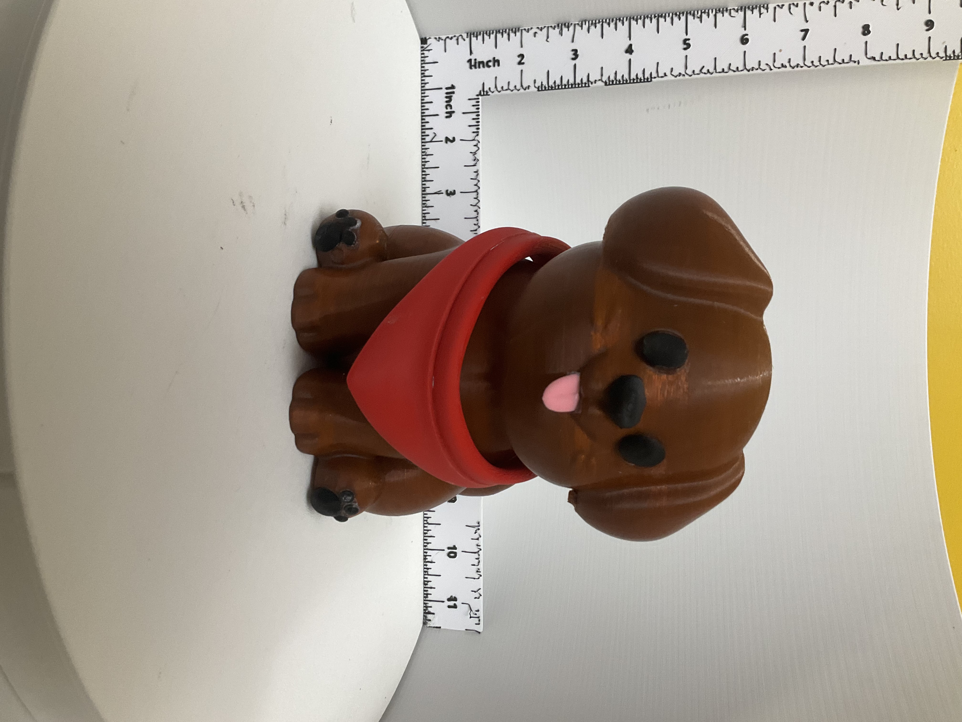 Front view of smiling brown puppy holder with red bandana and pink tongue
