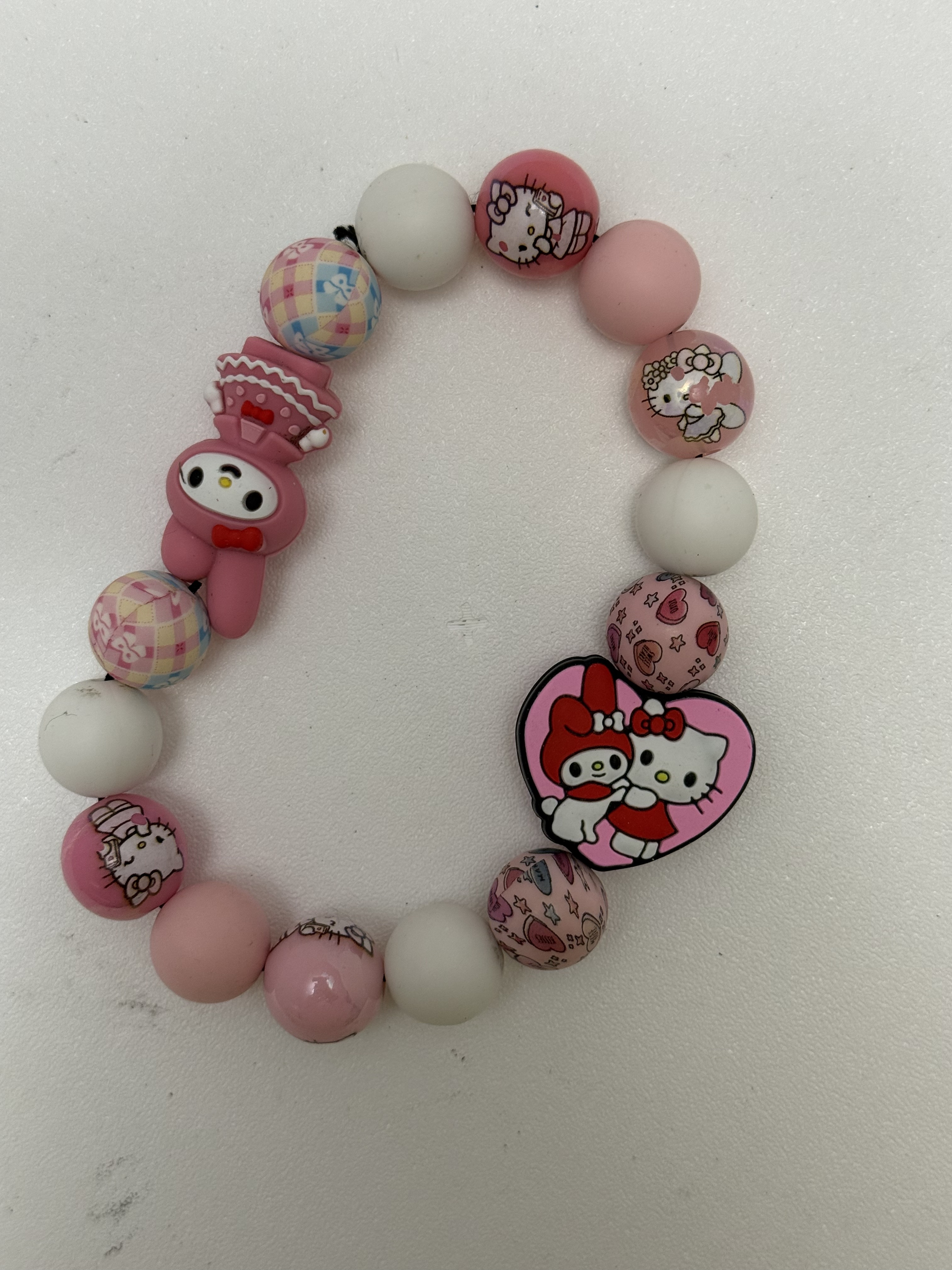 Pink and white beaded stretch bracelet with kawaii character charms and printed beads