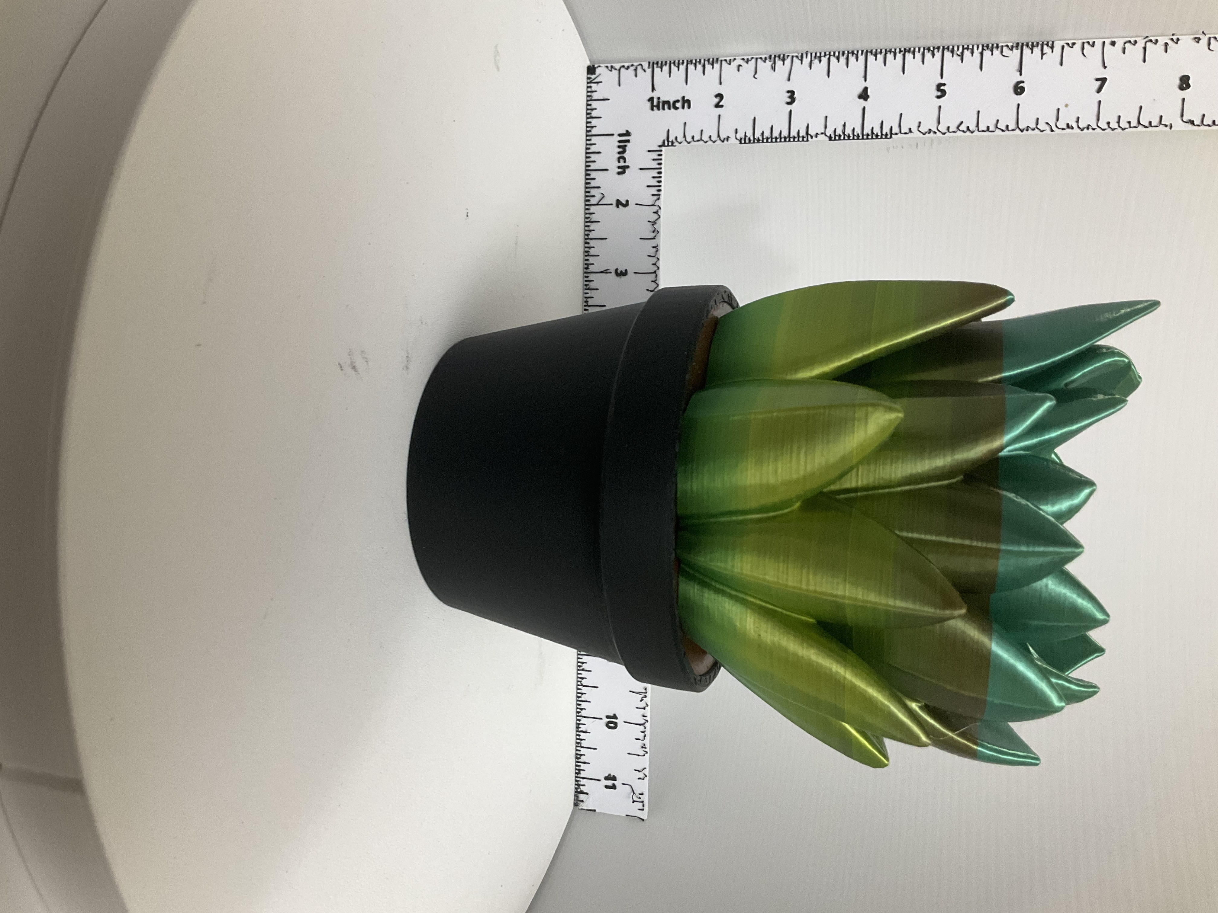 3D printed succulent soap dispenser holder with shimmery green-to-teal leaves in matte black pot