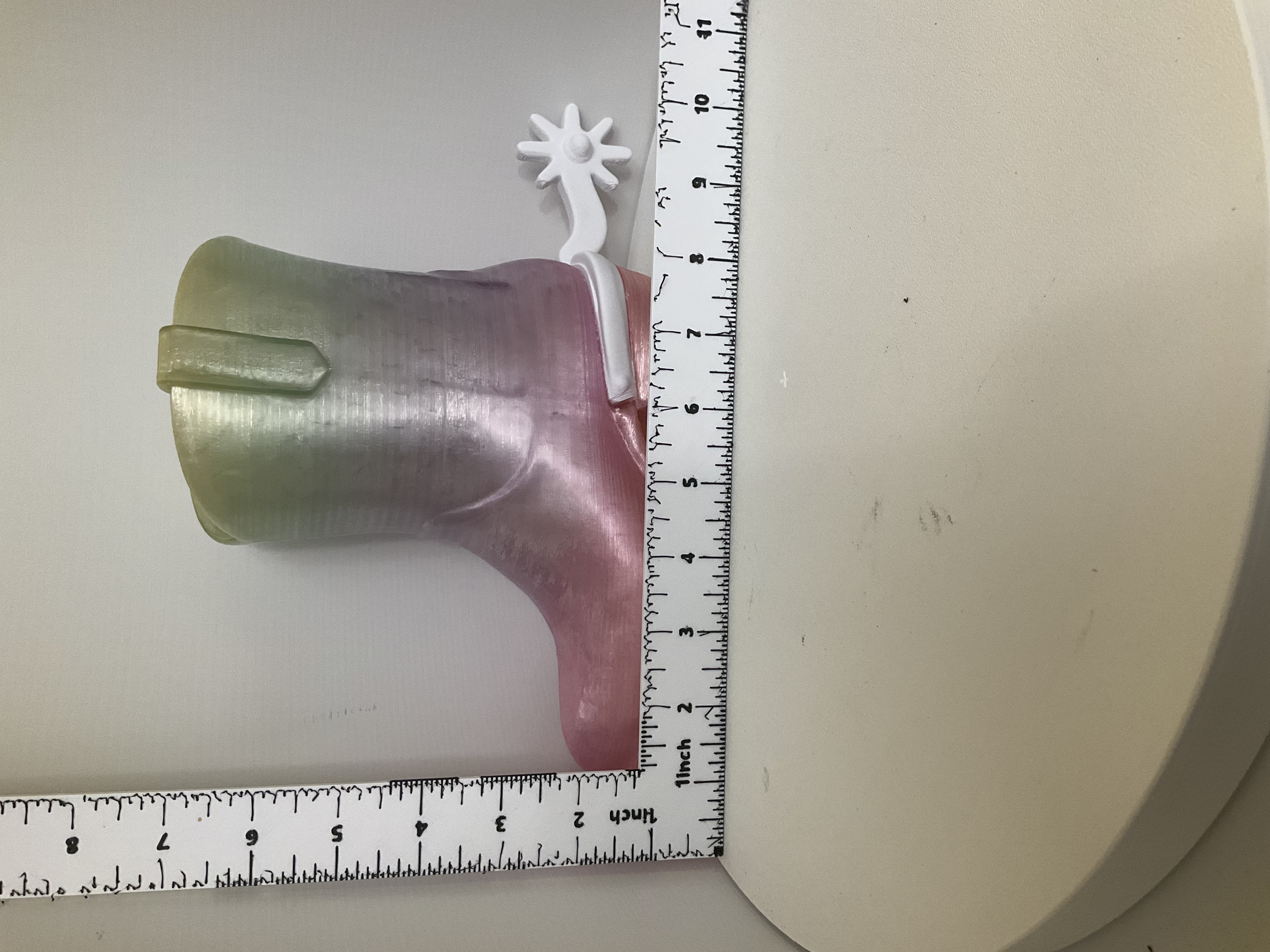 Side view of cowboy boot soap dispenser holder shown next to ruler for scale reference