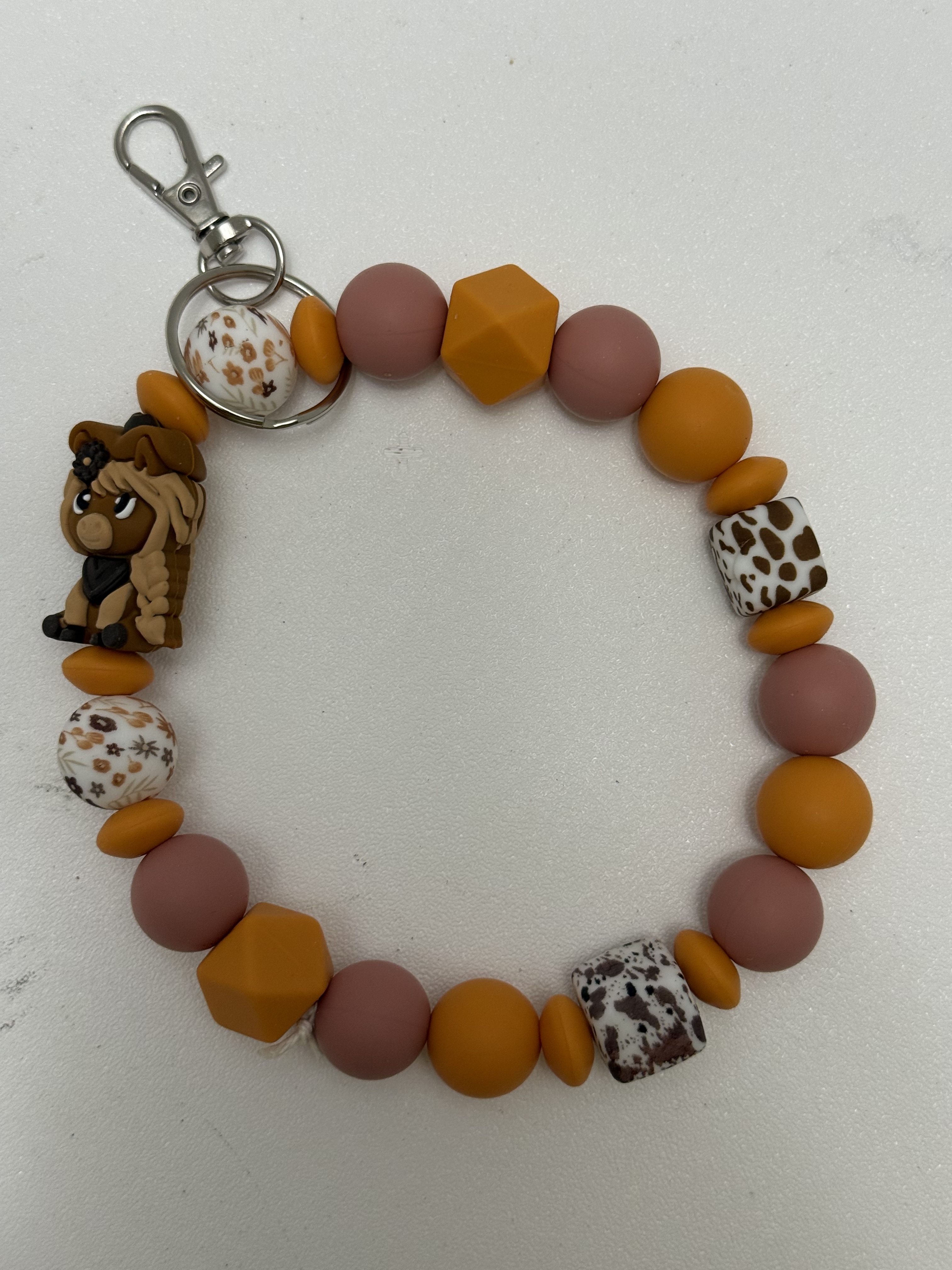 Beaded wristlet keychain with mustard, dusty rose, floral and spotted beads and a kawaii pony charm