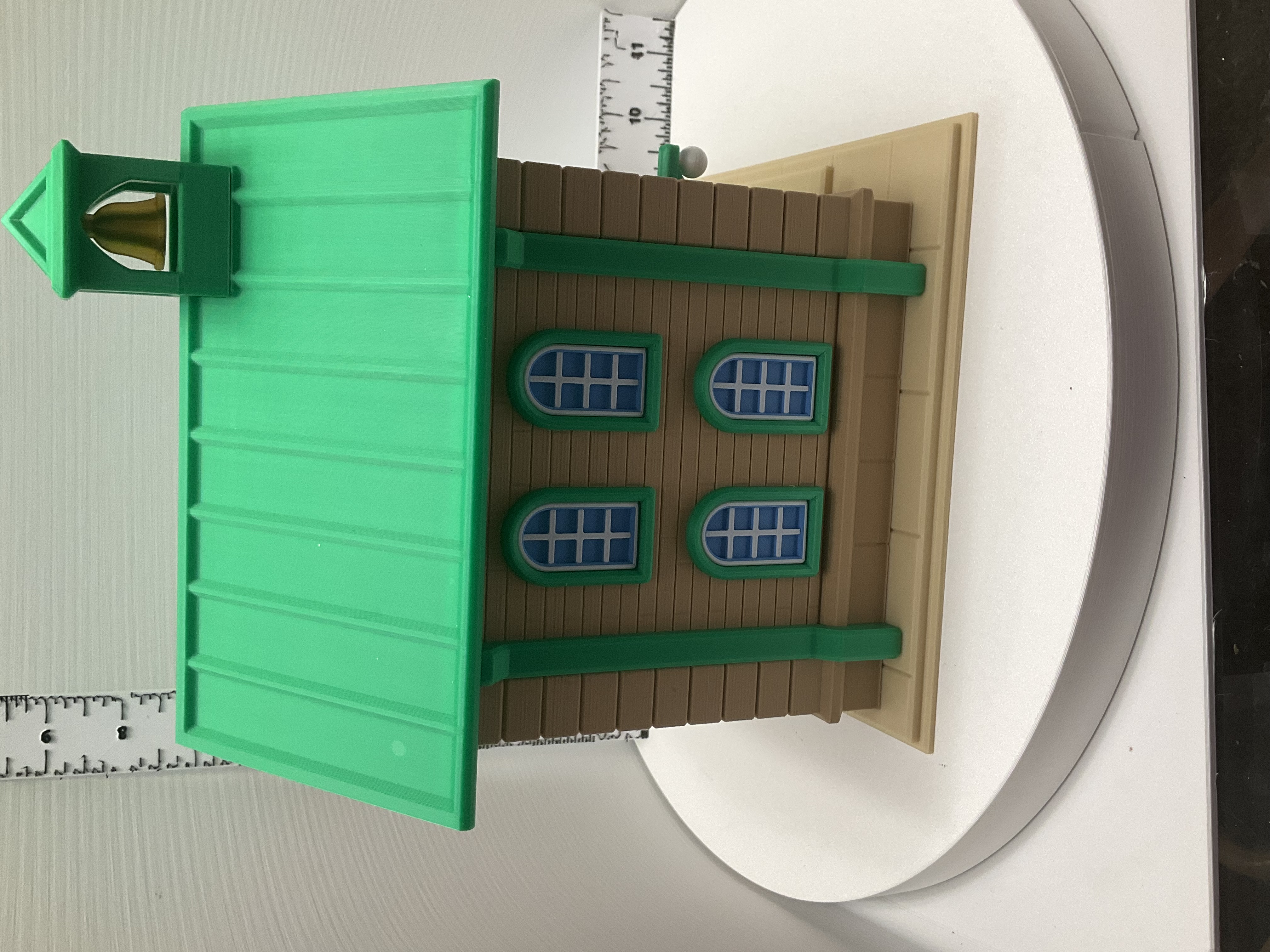 Rear view of schoolhouse birdhouse showing four arched blue windows and green columns