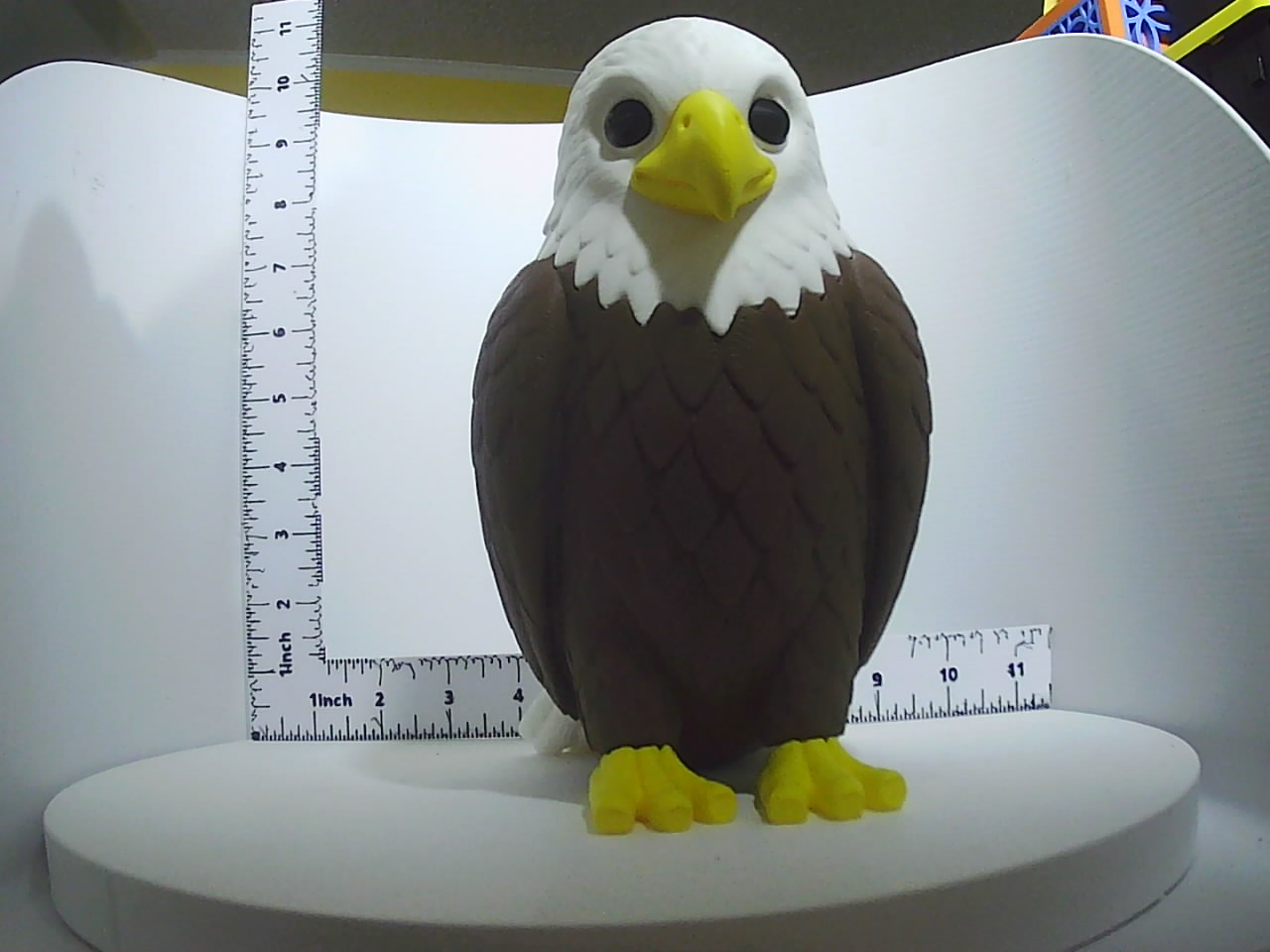 3D printed bald eagle figurine with brown body, white head, and yellow beak standing upright